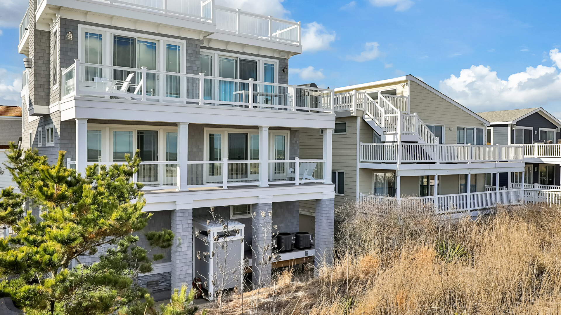 Exterior of modern beach home boasting multiple balconies, including a private roof deck, Long Beach Island NJ